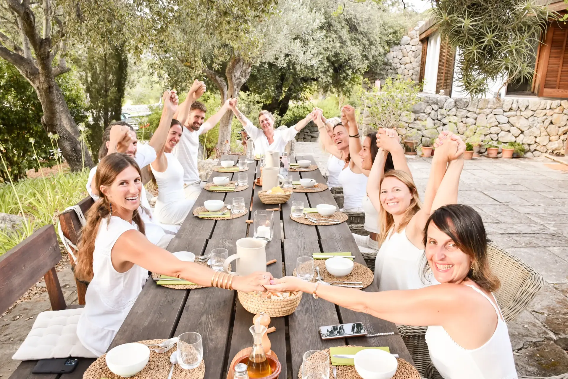 Group of retreat participants celebrating together at the dining table at Yoga of the Soul retreat in Mallorca